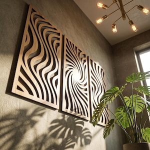 Puede incluir: Un conjunto de tres paneles de pared rectangulares de madera con intrincados diseños cortados con láser. Los paneles exteriores muestran patrones de ondas verticales fluidas, mientras que el panel central presenta un diseño en espiral radiante.