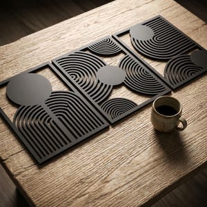 May include: Three rectangular black wall art panels featuring intricate laser-cut geometric patterns of concentric semicircles and solid circles. The panels are arranged in a row, showcasing a repeating linear design with a matte finish.