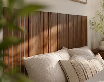 May include: A rectangular headboard constructed from vertical dark brown wooden slats. The headboard is positioned behind a bed featuring two white pillows and a rectangular accent pillow with a brown and white striped pattern.