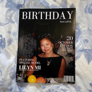 Op de afbeelding: Een magazinecover met de titel "BIRTHDAY MAGAZINE" in grote witte letters. De cover toont een foto van een vrouw, met de tekst "20 OCTOBER EDITION" en "FEATURING SPECIAL MODEL LILYN MI". De achtergrond is een bloemenpatroon.