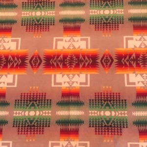 May include: A fabric featuring a repeating geometric pattern in shades of tan, red, orange, yellow, and green. The design consists of symmetrical diamond and rectangular shapes composed of small triangles and lines arranged in a horizontal layout.