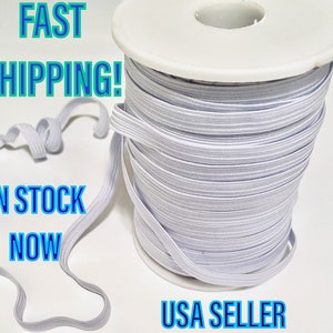 May include: A spool of white elastic cord with a white plastic spool. The elastic cord is wound tightly around the spool. The text "FAST SHIPPING! IN STOCK NOW USA SELLER" is visible in the image.