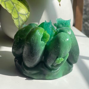 Könnte beinhalten: Eine einzigartige, abstrakte Skulptur in Grüntönen. Das Stück hat abgerundete, organische Formen mit glänzendem Finish, was eine visuell interessante und moderne Ästhetik schafft. Die Skulptur ist ein dekorativer Gegenstand.
