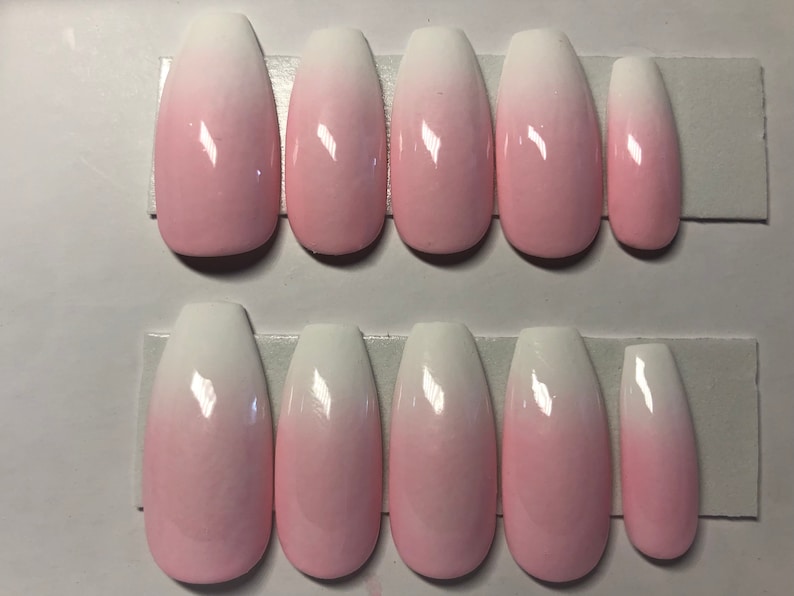 May include: Set of ten ombre pink and white coffin shaped fake nails.