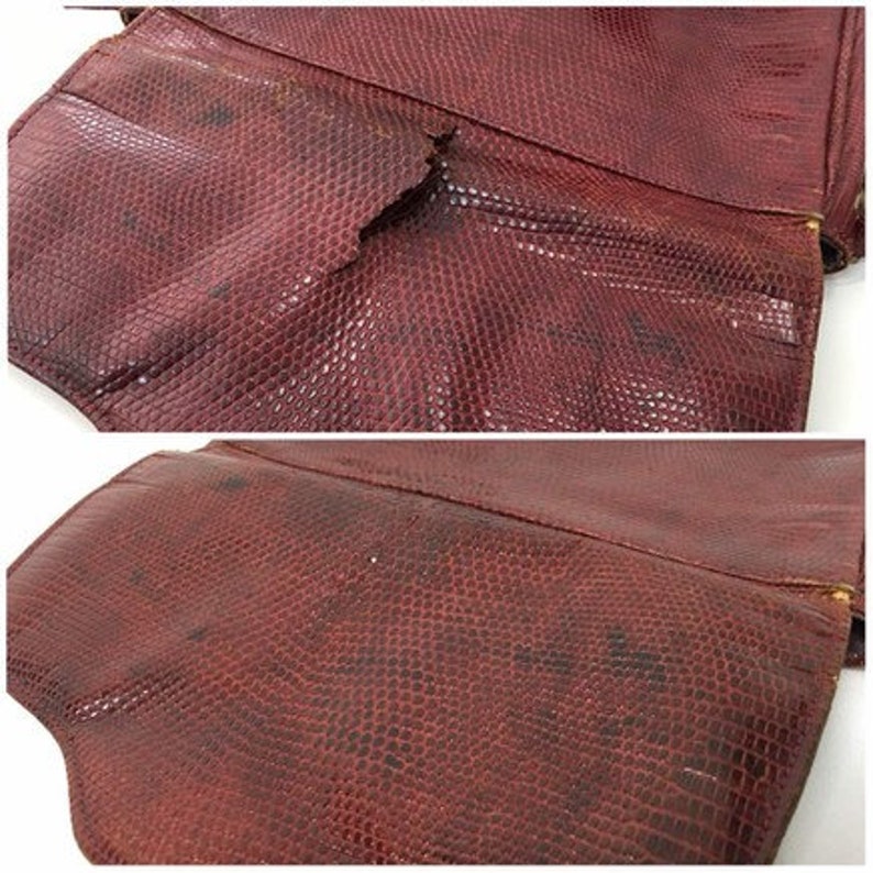 May include: A close-up of a burgundy leather purse with a textured, snake-like pattern. The purse has a flap closure and a small tear on the front.