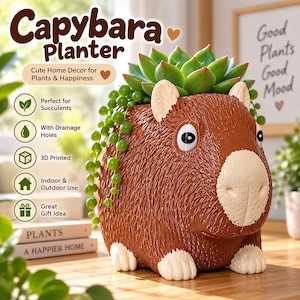 May include: A brown capybara-shaped planter with a textured surface, white snout, and white paws. The planter holds a green succulent and a trailing string of pearls plant. Text on the image includes Capybara Planter, Cute Home Decor for Plants & Happiness, Perfect for Succulents, With Drainage Holes, 3D Printed, Indoor & Outdoor Use, and Great Gift Idea.