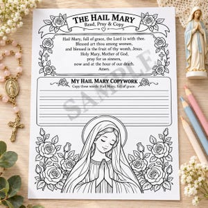 May include: A white paper worksheet titled The Hail Mary, featuring the prayer text, a copywork section with lined space, and a line art illustration of the Virgin Mary surrounded by roses. The design includes decorative floral borders and crosses.