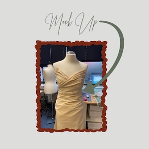 May include: A beige dress form with a draped fabric design. The dress form is in a studio setting, with a smaller form to the left. The text "Mock Up" is written in cursive above the dress form.