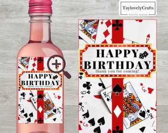 Può includere: Un'etichetta per bottiglia di vino stampabile con un design rosso, bianco e nero con carte da gioco e il testo "Buon compleanno, grazie per essere venuto!"
