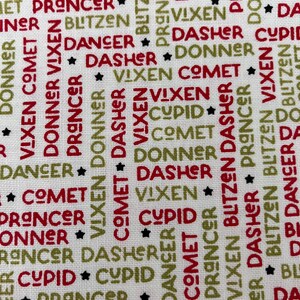 May include: White fabric featuring a festive pattern of Christmas reindeer names in red and green. Names such as Dasher, Dancer, Prancer, and Vixen are displayed with black star accents.