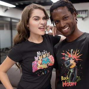 K&ouml;nnte beinhalten: Zwei Personen tragen schwarze T-Shirts mit Katzenmotiven. Das Shirt der Frau zeigt eine Katzenband namens "The Meows" mit dem Text "All You Need Is Cats". Das Shirt des Mannes zeigt eine Katze, die als Rockstar verkleidet ist, mit dem Text "Rock and Meow".