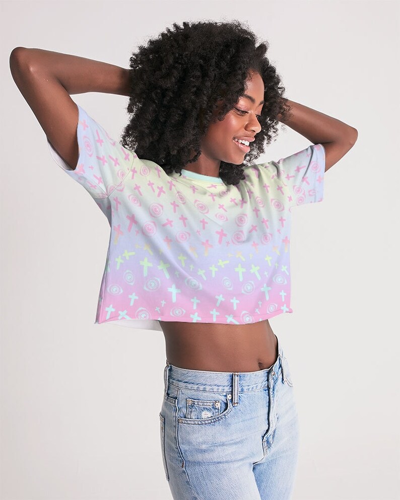 May include: A pastel rainbow crop top with a pattern of pink crosses and swirls. The top is made of a soft, comfortable fabric and has a relaxed fit.
