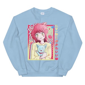 May include: A light blue sweatshirt with a graphic of a pink-haired anime girl holding a blue cat. The text "すきとかわいい" is printed on the right side of the graphic.