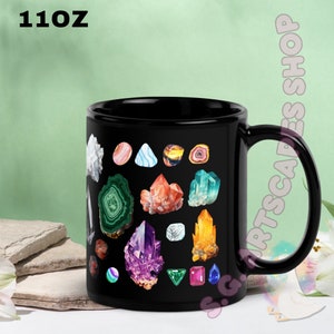 May include: Black 11oz ceramic mug featuring colorful illustrations of various crystals and gemstones. The mug has a large handle and is suitable for hot or cold beverages. The text "11OZ" is printed on the top left.