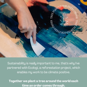Op de afbeelding: Een hand gebruikt een wit paletmes om blauwe, groene en roze verf te mengen op een canvas. Het canvas heeft een witte cirkel met de tekst "FOR EVERY ORDER TREE PLANTED" en een klein blaadjesontwerp in het midden.