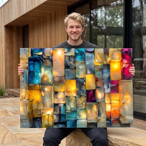 Peut inclure: Une œuvre d'art murale rectangulaire composée de nombreux segments de résine translucides en forme de blocs, dans des tons bleu profond, ambre, jaune et magenta. L'œuvre intègre un éclairage interne qui illumine les blocs texturés et colorés.