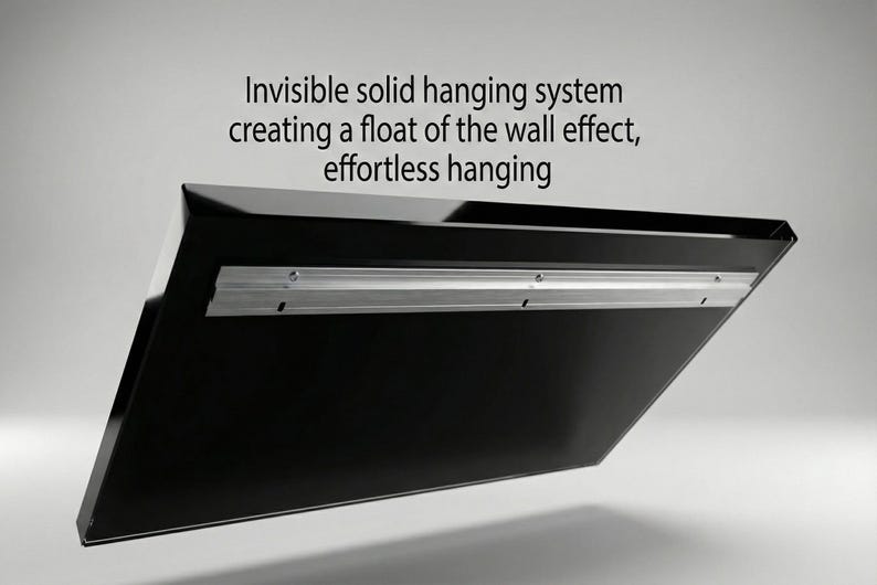 May include: A black, angled panel with a silver mounting bracket. The text reads: "Invisible solid hanging system creating a float of the wall effect, effortless hanging."