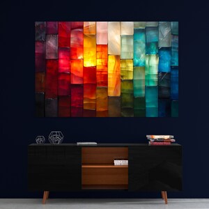 May include: A large, colourful abstract artwork composed of rectangular blocks in a spectrum of colours, from deep reds to vibrant blues. The artwork hangs above a black cabinet with wooden accents and geometric decor.