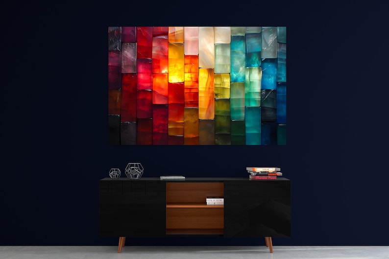 May include: A large, colourful abstract artwork composed of rectangular blocks in a spectrum of colours, from deep reds to vibrant blues. The artwork hangs above a black cabinet with wooden accents and geometric decor.