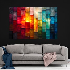 May include: A colourful abstract artwork, composed of vertical rectangular blocks in a gradient of colours. The piece, mounted above a grey sofa, transitions from red to blue. The room has a modern design with a black wall.