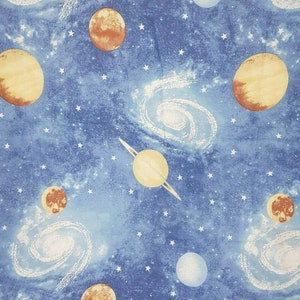 Può includere: Un tessuto blu a tema spaziale con pianeti, stelle e galassie. I pianeti sono in tonalità di arancione, giallo e marrone. Le stelle sono bianche e le galassie sono bianche e grigie.