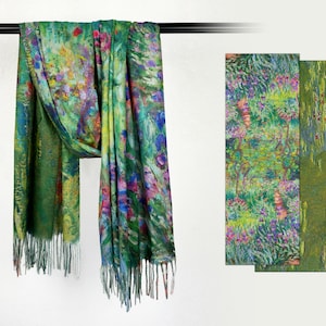 May include: A green scarf with a colorful floral design, hanging from a black rod. The scarf has a fringe at the bottom. Two additional panels with the same floral pattern are displayed to the right. The design features shades of green, blue, purple, and red.