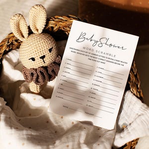Pode incluir: Um cart&atilde;o de jogo de ch&aacute; de beb&ecirc; imprim&iacute;vel com o t&iacute;tulo "Baby Shower Word Scramble". O cart&atilde;o tem uma lista de palavras embaralhadas relacionadas a beb&ecirc;s.
