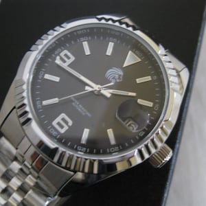 May include: A silver men's wristwatch with a black face and silver hands. The watch has a date window at the 3 o'clock position and a silver band.