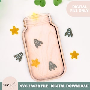 Puede incluir: Una bandeja de madera con forma de tarro, con un acabado de madera clara. La bandeja está decorada con pequeños recortes de cohetes grises y estrellas amarillas. El texto "DIGITAL FILE ONLY" es visible. La parte inferior de la imagen contiene el texto "SVG LASER FILE DIGITAL DOWNLOAD".