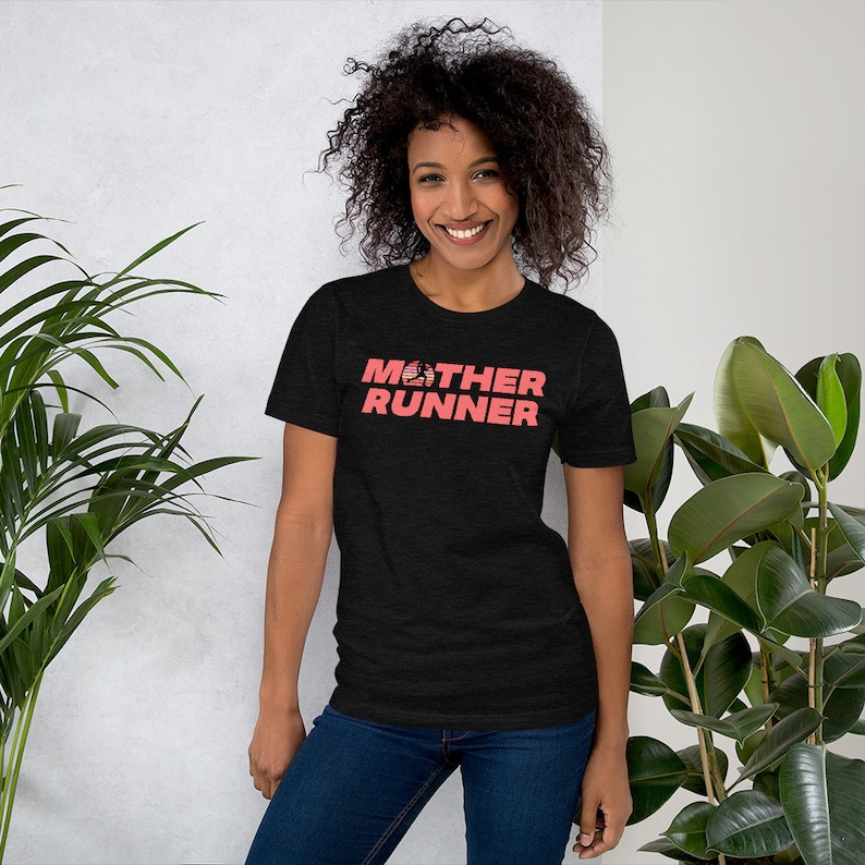 May include: A black short-sleeved t-shirt with the text "MOTHER RUNNER" in pink. The "O" in "MOTHER" is replaced with a stylized American flag.
