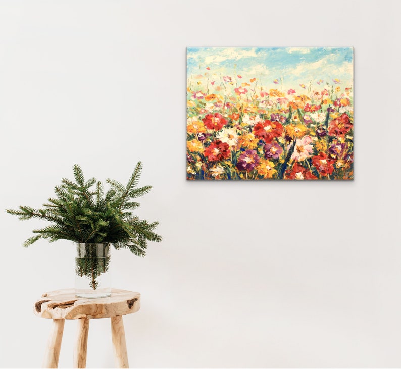 May include: A colorful painting of a field of flowers in various shades of red, yellow, orange, and pink. The flowers are painted in a loose, impressionistic style, with visible brushstrokes. The background is a soft blue sky with white clouds.