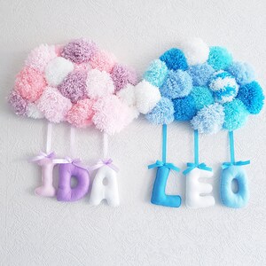 May include: Two fluffy pom-pom clouds with the names "IDA" and "LEO" hanging from them.