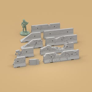 May include: A collection of gray concrete barriers with varying degrees of damage, including cracks and holes. A small green figurine of a person is standing near the barriers. The barriers are likely for a miniature wargame or diorama.