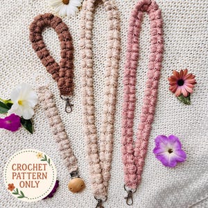 Puede incluir: Llaveros y pulseras de ganchillo en tonos marrón y rosa, con un patrón texturizado similar a flores. Los llaveros tienen cierres metálicos. La imagen también incluye un clip para chupete y el texto "CROCHET PATTERN ONLY".