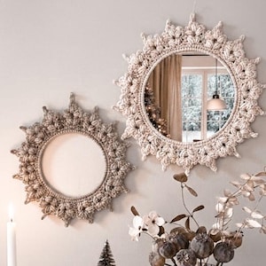 Puede incluir: Una composición decorativa con dos espejos de ganchillo, un espejo enmarcado, velas en candelabros de latón, un pequeño árbol de Navidad, un libro antiguo y una jarra de leche de metal con flores secas. Paleta de colores neutros.