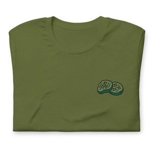 May include: A green t-shirt with a small embroidered image of two pickle slices.