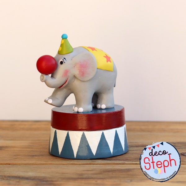 Eléphant de cirque au vallon rouge qui joue son numéro, poser sur un socle boîte en papier mâché et polymère, à personnaliser