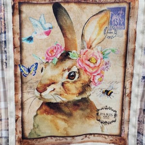 May include: A vintage-style illustration of a brown rabbit with a floral crown, a blue bird, a butterfly, and a bee. The image has a faded, antique look and includes the text "Paris 1911".