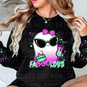 May include: A black sweatshirt with a pink and green ghost wearing sunglasses and holding a purse and a drink. The ghost has a pink bow on its head. The text "FABOOOLOUS" is written in pink and green letters below the ghost.