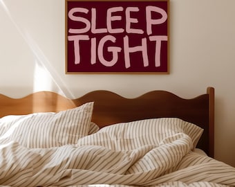 May include: A white and gray striped bedspread with a wooden headboard. A framed print with the text "SLEEP TIGHT" in pink letters on a burgundy background hangs above the bed.
