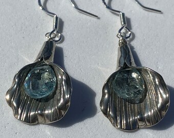 Handmade earrings featuring faceted teardrop-shaped aquamarine and enveloped in an organic shaped sterling silver piece