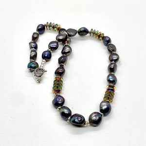 Large cultured freshwater pearls in hues of grey, brown and burgundy accented with complementary glass discs and sterling silver.