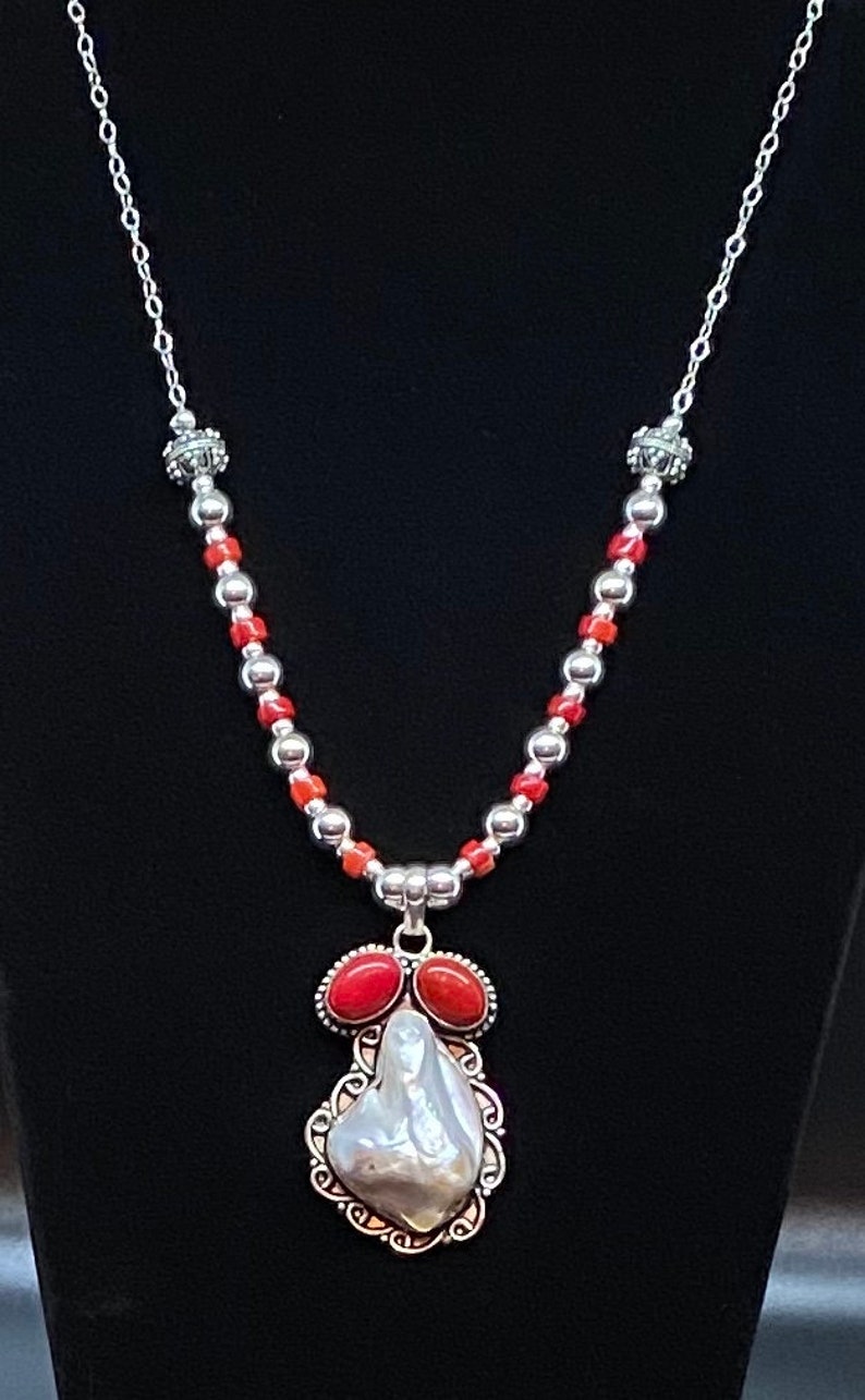Distinctive pendant of shell and coral set in sterling silver is featured in this handmade necklace