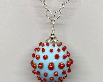 Spunky, textured lampwork glass bead in turquoise with raised red bumps, finished in sterling and hanging from sterling silver chain