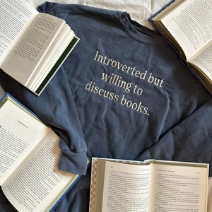 Może przedstawiać: Granatowa bluza z haftem "Introvert, ale chętny do dyskusji o książkach" na przodzie.