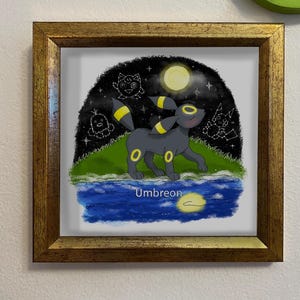 Może przedstawiać: Oprawiona grafika przedstawiająca czarnego Umbreona z żółtymi akcentami, na tle nocnego nieba z gwiazdami i pełnią księżyca. Grafika zawiera zbiornik wodny i napis "Umbreon". Rama jest złota.