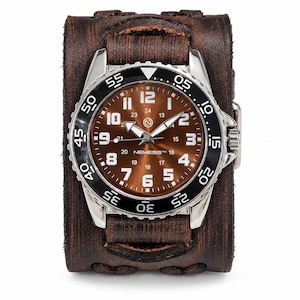 May include: A wristwatch with a brown dial featuring white numerals and the text NEMESIS, housed in a silver-tone case with a black rotating bezel. The watch is attached to a wide, dark brown distressed leather cuff strap with visible stitching.
