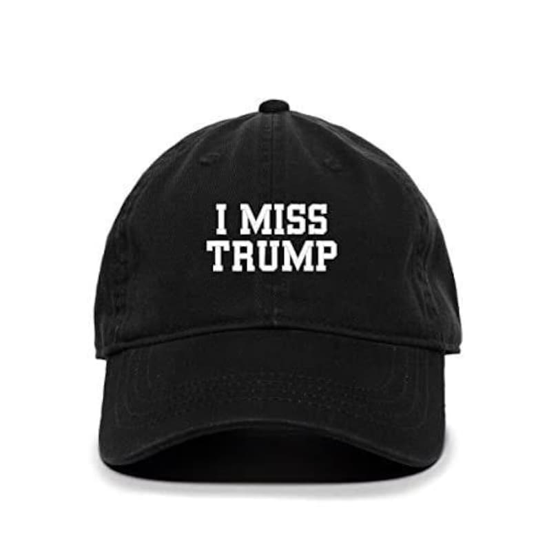 Pode incluir: Bon&eacute; de beisebol preto com texto bordado em branco que diz "I MISS TRUMP".