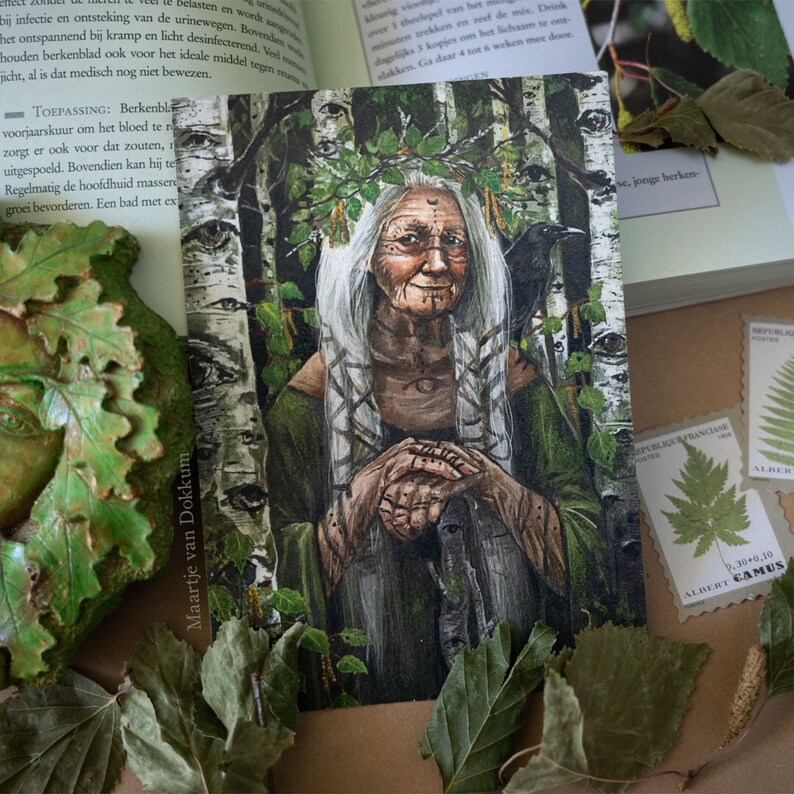 Pode incluir: Uma mulher com cabelo comprido e branco e uma coroa de folhas est&aacute; sentada em uma floresta. Ela est&aacute; vestindo uma t&uacute;nica verde e tem um corvo em seu ombro. O fundo &eacute; uma floresta de b&eacute;tulas.