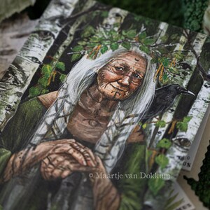 Pode incluir: Uma pintura de uma mulher mais velha com cabelo comprido e branco e uma coroa de folhas. Ela est&aacute; vestindo um vestido verde e tem um corvo preto em seu ombro. O fundo &eacute; uma floresta de b&eacute;tulas.